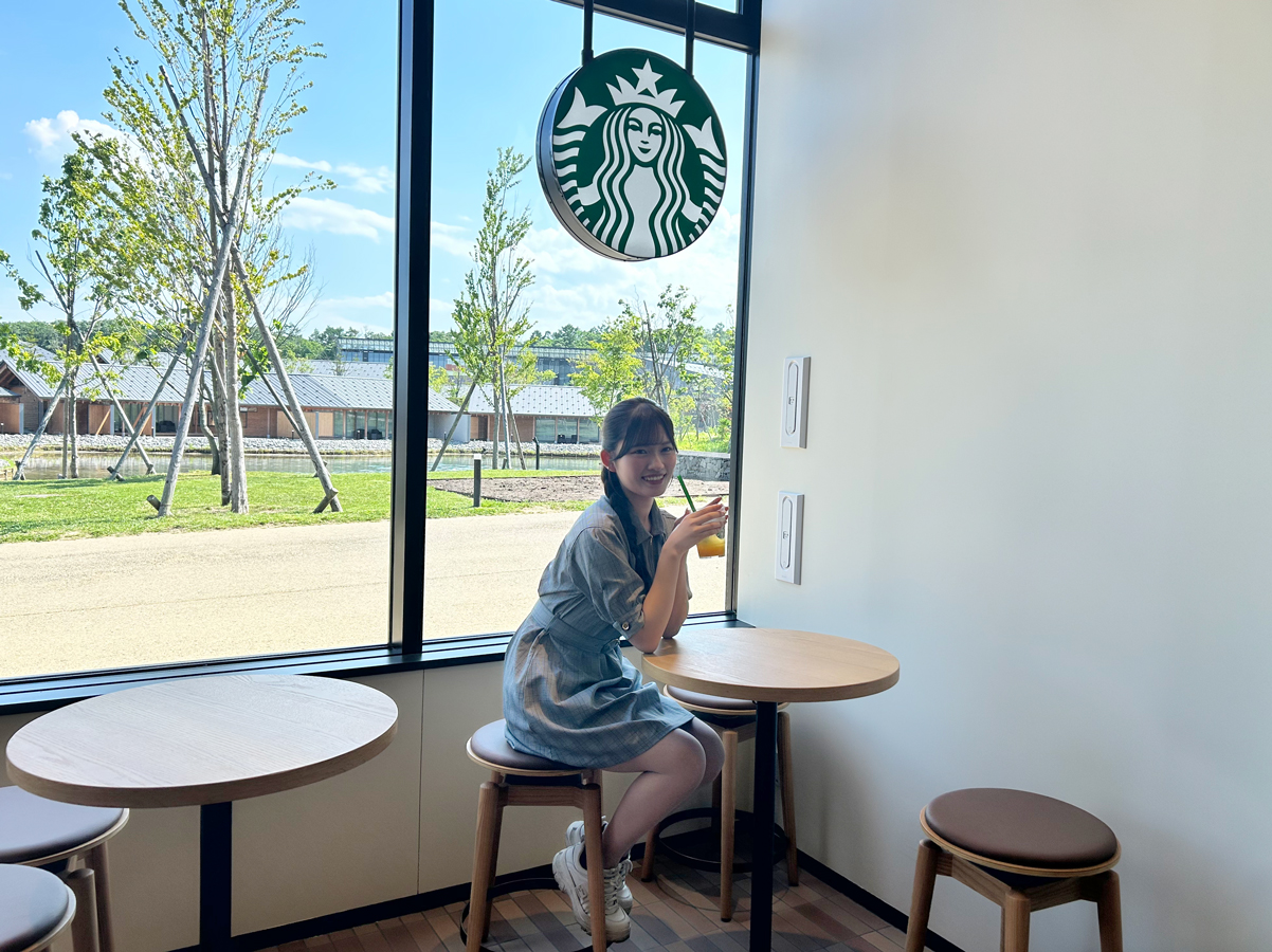 窓際のハイテーブル席。目の前にはFビレッジの緑豊かな景色が広がります
