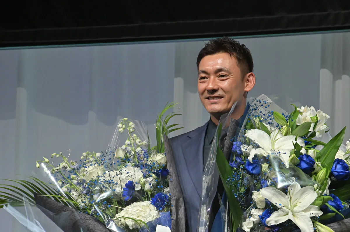 El jugador Takumi Kuriyama sonríe al recibir un ramo de flores ©PLM