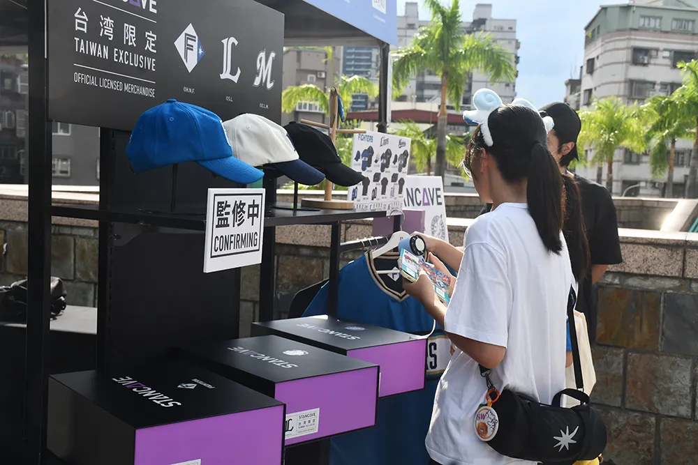 台湾限定グッズを手に取るファン【©PLM】