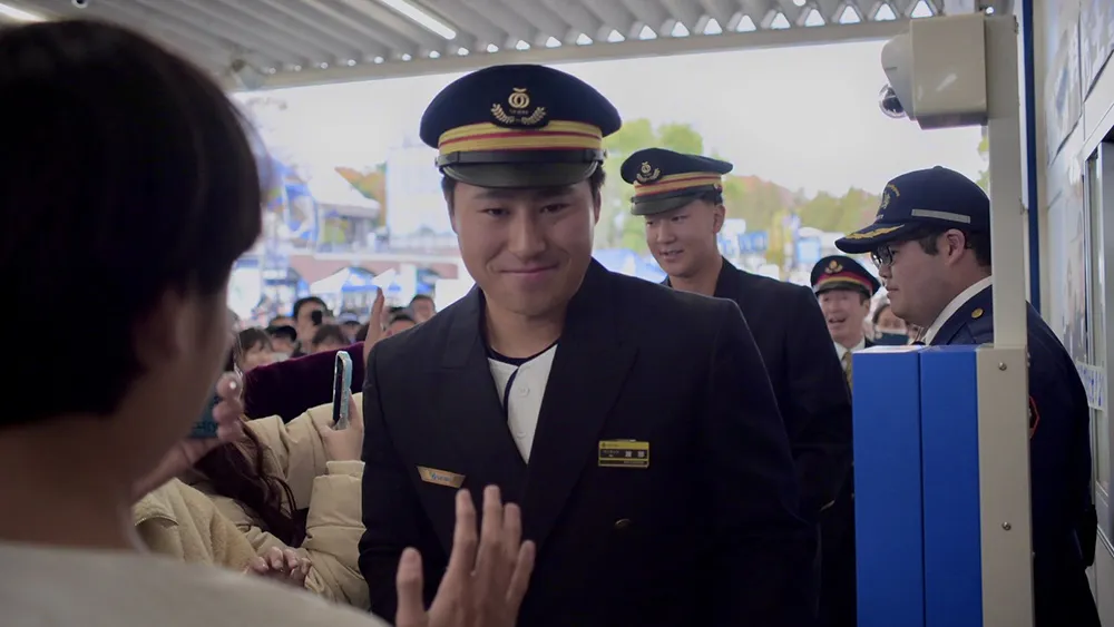 駅係員に扮した渡部聖弥選手 ©PLM