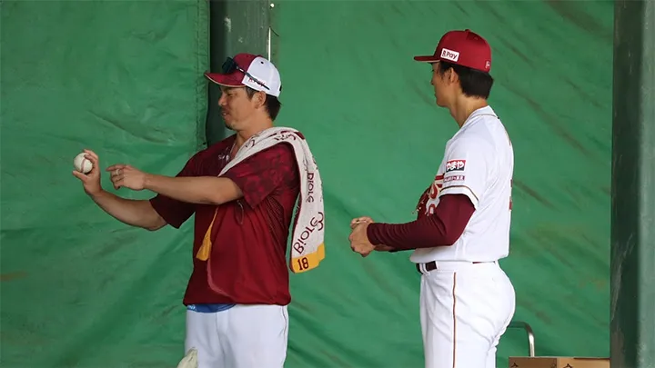 ツーシームの握りについて意見を交わす、前田健太投手と荘司康誠投手。若手とベテランが混ざり合い、互いをサポートし合う雰囲気がブルペンでも感じられた【©PLM】