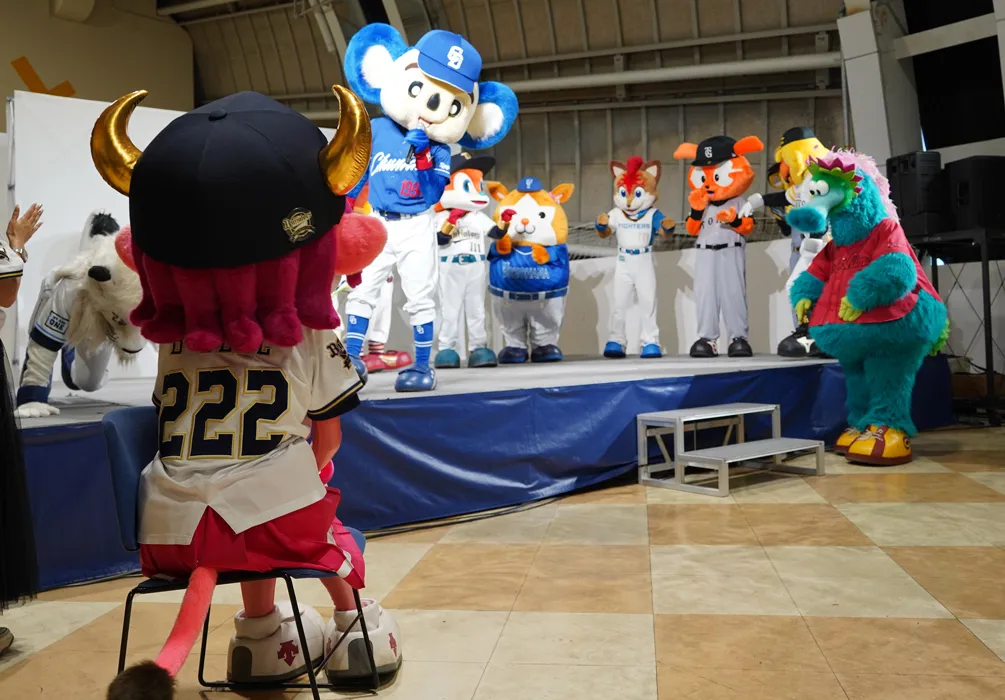 「野球場へいこう」を歌うマスコットたちを見つめるベルちゃん