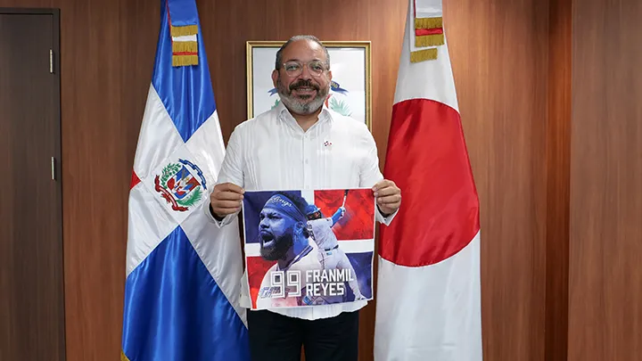 「ドミニカ共和国DAY」で来場者に配布したレイエス選手のスイングタオルを持つペレス大使【パ・リーグインサイト撮影】