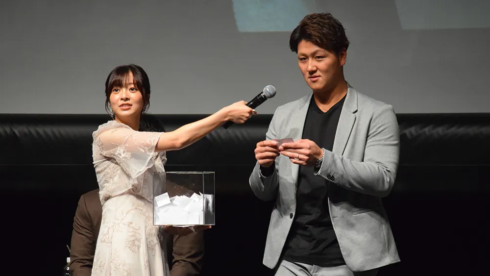 菊池柚花さん(左)とサインボールの当選者を読み上げる千葉ロッテマリーンズ・山口航輝選手(右)©PLM