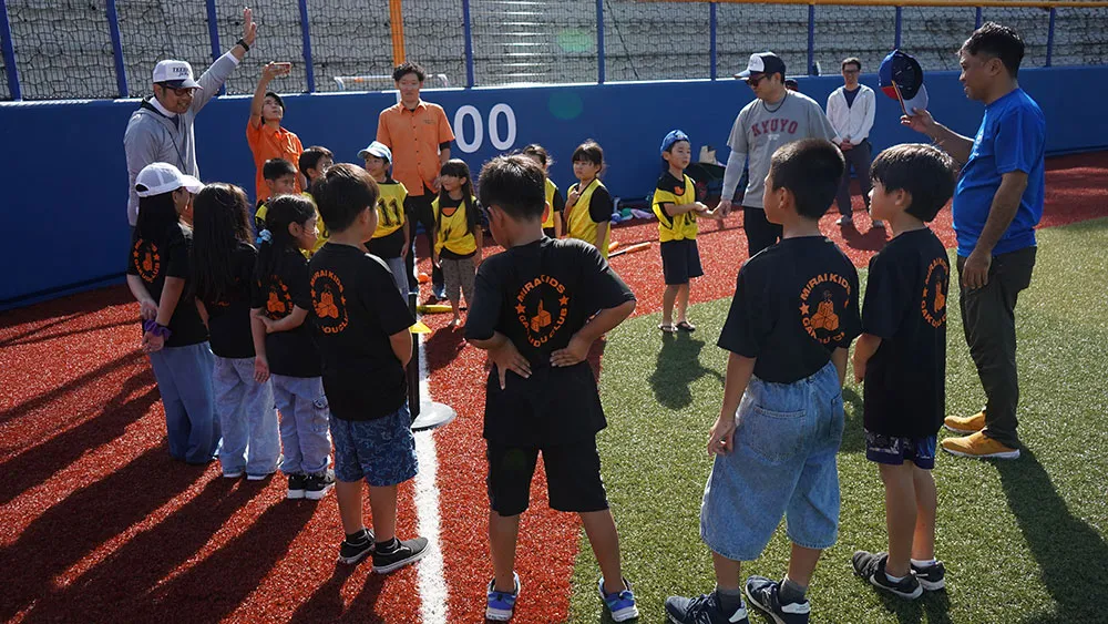 試合形式のプレーについて説明をうける子どもたち【©JWL】
