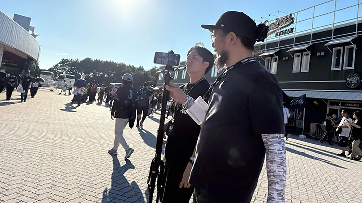 ハンディカメラで取材対象者を追う ©PLM